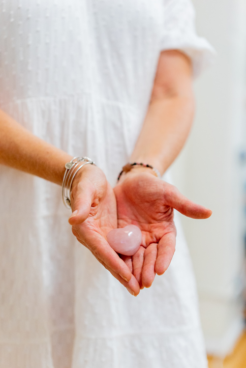 Hands holding a smooth pink stone